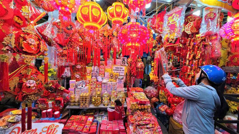 Cảnh mua bán hoa vạn thọ nhộn nhịp và rực rỡ tại một chợ hoa truyền thống vào dịp Tết Nguyên Đán, thể hiện không khí tưng bừng chuẩn bị đón Xuân.